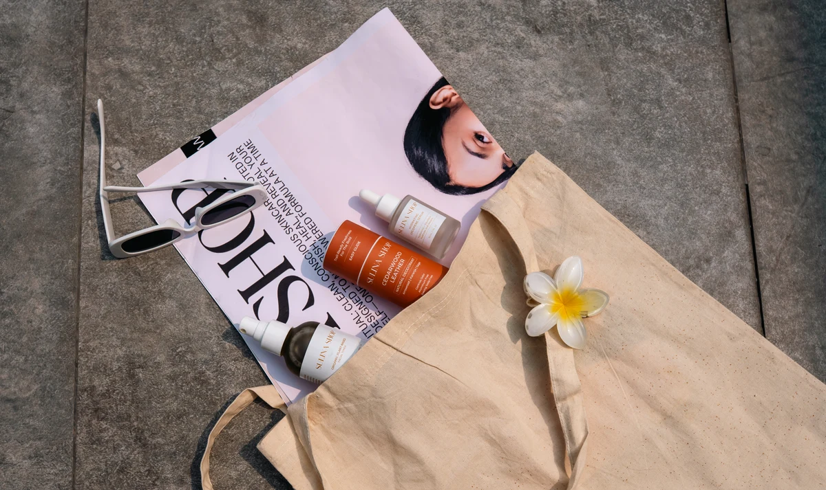 Sulina Shop products arranged with a magazine, sunglasses and canvas tote