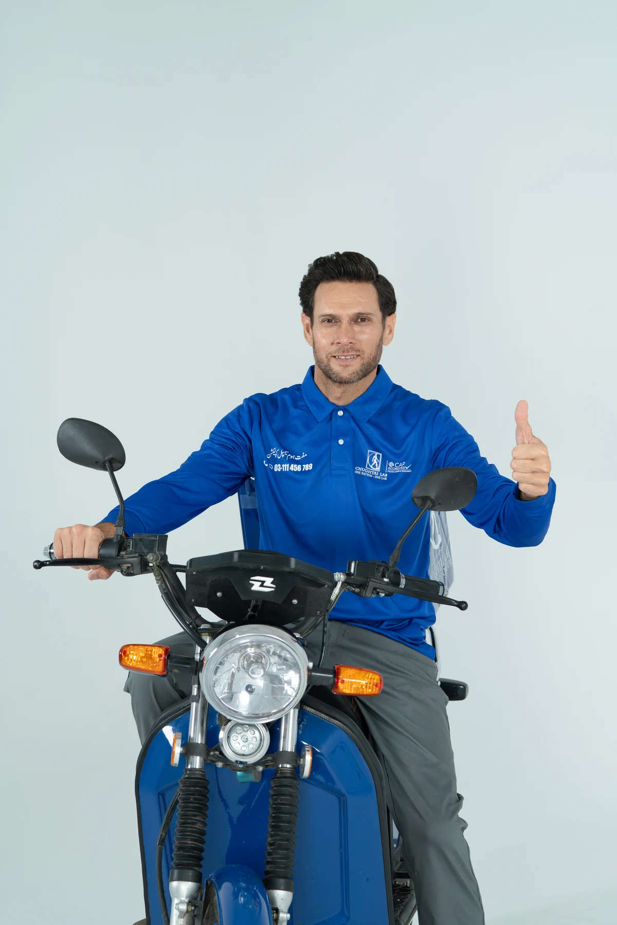 Chughtai Lab campaign portrait of a rider in a blue uniform on a motorcycle